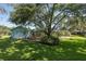 Spacious backyard with a covered pool, deck, and mature trees, offering a private and tranquil setting at 3609 Montclair Dr, New Port Richey, FL 34655