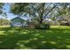 Large backyard with a pool, deck, and lush landscaping, perfect for outdoor entertaining and relaxation at 3609 Montclair Dr, New Port Richey, FL 34655