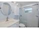 This bathroom has a white vanity and a step-in shower with glass door at 3609 Montclair Dr, New Port Richey, FL 34655