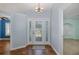 Bright foyer with decorative front door, tile flooring, and neutral paint, leading to other rooms at 3609 Montclair Dr, New Port Richey, FL 34655
