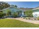 Inviting front entrance with a brick walkway, lush landscaping, and a charming light blue exterior at 3609 Montclair Dr, New Port Richey, FL 34655