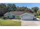Charming single-story home with a well-manicured lawn and a two-car garage and light blue exterior at 3609 Montclair Dr, New Port Richey, FL 34655