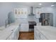 Bright kitchen with white cabinets, stainless steel appliances, a farmhouse sink, and an eat-in center island at 3609 Montclair Dr, New Port Richey, FL 34655