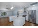 Spacious kitchen with stainless steel appliances, white cabinets, center island, and large format tile floors at 3609 Montclair Dr, New Port Richey, FL 34655