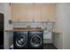 A convenient laundry room with black washer and dryer, cabinets, and granite countertops at 3609 Montclair Dr, New Port Richey, FL 34655