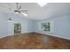 Large living room with tile floors, a ceiling fan, and a sliding glass door to the screened lanai at 3609 Montclair Dr, New Port Richey, FL 34655