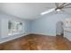 Bright living room featuring tile floors, a ceiling fan, and a large window with plantation shutters at 3609 Montclair Dr, New Port Richey, FL 34655