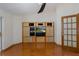 Cozy living room with wood floors, entertainment center, and access to a screened lanai at 3609 Montclair Dr, New Port Richey, FL 34655