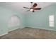 Main bedroom showcases a ceiling fan, neutral walls, carpet floors, and an arched window with shutters at 3609 Montclair Dr, New Port Richey, FL 34655
