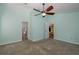 Main bedroom with carpet, neutral walls, ceiling fan, and ensuite bathroom, offering a relaxing retreat at 3609 Montclair Dr, New Port Richey, FL 34655
