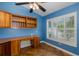 Bright office with built-in desk and shelving, tile floors, and a window with plantation shutters at 3609 Montclair Dr, New Port Richey, FL 34655