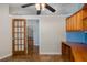 Home office featuring a built-in desk, overhead shelves, tile floor and door to a living area at 3609 Montclair Dr, New Port Richey, FL 34655