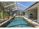 A beautiful enclosed pool features a waterfall surrounded by trees and greenery at 3609 Montclair Dr, New Port Richey, FL 34655