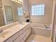 Bright bathroom with double vanity, jacuzzi tub, and glass block window at 3627 Muirfield Ct # 3627, New Port Richey, FL 34655
