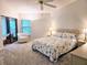 Bright bedroom with a floral-patterned quilt, ceiling fan, and sliding doors to a lanai at 3627 Muirfield Ct # 3627, New Port Richey, FL 34655