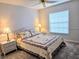 Comfortable bedroom with a queen-size bed, ceiling fan, and large window at 3627 Muirfield Ct # 3627, New Port Richey, FL 34655