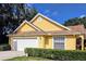 Charming yellow home featuring a two-car garage, and well-maintained front yard, creating a welcoming curb appeal at 3627 Muirfield Ct # 3627, New Port Richey, FL 34655