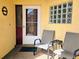 Inviting front porch featuring chairs, decorative wreath, and glass block window accents at 3627 Muirfield Ct # 3627, New Port Richey, FL 34655