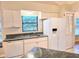 Functional kitchen featuring granite counters, white cabinets, and stainless-steel sink at 3627 Muirfield Ct # 3627, New Port Richey, FL 34655