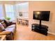 Bright living room with desk and chair nook, modern TV and stand, and wood floors for a modern feel at 3627 Muirfield Ct # 3627, New Port Richey, FL 34655