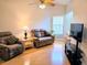 Comfortable living room with plush seating, wood floors, and a ceiling fan, creating a cozy and inviting space at 3627 Muirfield Ct # 3627, New Port Richey, FL 34655