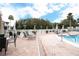 A resort-like pool deck offers lounge chairs and tables shaded by umbrellas for relaxing by the water at 3627 Muirfield Ct # 3627, New Port Richey, FL 34655