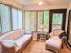 Cozy sunroom with wicker furniture, complemented by natural light filtering through large windows at 3627 Muirfield Ct # 3627, New Port Richey, FL 34655