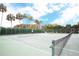 Beautifully maintained community tennis court surrounded by lush landscaping and mature palm trees at 3627 Muirfield Ct # 3627, New Port Richey, FL 34655