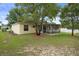 Relax in the shaded backyard with a screened porch overlooking the lush lawn at 3631 Celebration Dr, Brooksville, FL 34604