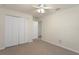 Carpeted bedroom with ceiling fan, closet with folding doors, and ample natural light at 3631 Celebration Dr, Brooksville, FL 34604