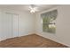 Bright bedroom features a ceiling fan, closet with folding doors, and a window with stylish curtain at 3631 Celebration Dr, Brooksville, FL 34604
