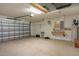 View of the spacious garage featuring a work bench and abundant storage shelving at 3631 Celebration Dr, Brooksville, FL 34604