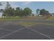 Fenced community tennis court surrounded by green space and mature trees at 3631 Celebration Dr, Brooksville, FL 34604
