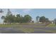 Fenced community tennis court surrounded by green space and mature trees at 3631 Celebration Dr, Brooksville, FL 34604