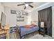 Cozy bedroom features ceiling fan, black and white photos, and a window with dark curtains at 3886 Reflection Dock Dr, Seffner, FL 33584