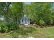 View of the stylish blue shed with white trim nestled among the trees at 4009 Clear Spring Rd, Brooksville, FL 34604