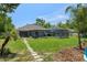 Expansive backyard featuring a screened lanai, lush landscaping, and stepping stone path at 4009 Clear Spring Rd, Brooksville, FL 34604