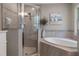 Bathroom featuring a glass-enclosed shower and a soaking tub with tiled surround at 4009 Clear Spring Rd, Brooksville, FL 34604