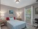 This is a bedroom with a queen size bed and a small desk with a chair, all illuminated by natural light at 4009 Clear Spring Rd, Brooksville, FL 34604