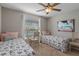 Bright bedroom featuring two twin beds, a ceiling fan, a painting, and a small desk at 4009 Clear Spring Rd, Brooksville, FL 34604
