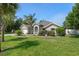 Landscaped home featuring well-maintained lawn, decorative trees, and a paved driveway at 4009 Clear Spring Rd, Brooksville, FL 34604