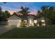 Charming single-story home featuring a two-car garage, beautifully landscaped yard, and a quaint, welcoming entrance with a teal door at 4009 Clear Spring Rd, Brooksville, FL 34604