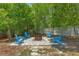 Secluded backyard fire pit area with Adirondack chairs, surrounded by mature trees at 4009 Clear Spring Rd, Brooksville, FL 34604