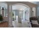 Inviting foyer features cool colors, light tile flooring, decorative front door and an ornate chair with a patterned rug at 4009 Clear Spring Rd, Brooksville, FL 34604