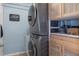 A modern laundry room features a stacked washer and dryer set with wooden cabinets on the side at 4009 Clear Spring Rd, Brooksville, FL 34604