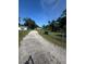 Long gravel driveway leading to a charming property with ample parking space at 410 Houle Ave, Sarasota, FL 34232
