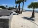 A beach view showcasing lush palms, picnic tables, clear ocean, and a relaxing coastal setting at 4726 Marine Pkwy # 104, New Port Richey, FL 34652