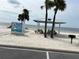 Quaint beach featuring a mural of a pelican, picnic tables, and palm trees at 4854 Marine Pkwy # 103, New Port Richey, FL 34652