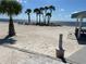 Expansive beach view featuring picnic tables, beachside trees, and views of the bay, perfect for seaside relaxation at 4854 Marine Pkwy # 103, New Port Richey, FL 34652