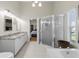 Primary bath with glass-enclosed shower, granite countertops, and white cabinets at 487 Waterloo Ct, Spring Hill, FL 34609